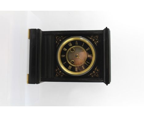 A LATE VICTORIAN BLACK SLATE MANTEL CLOCK, having gilded Roman numerals carved into dial, 8-day chiming movement, raised on b
