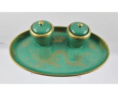 A CERAMIC STANDISH, having oval base fitted two inkwells with liners and covers, jade green glaze with gilded dragon decorati