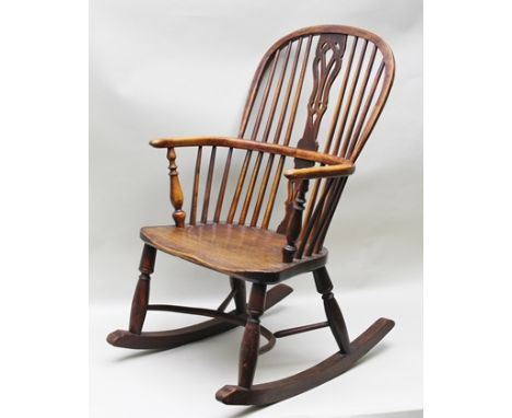 A 19TH CENTURY PROVINCIAL STICK AND PIERCED SPLAT OPEN ARM ROCKING CHAIR, having yew wood hoop back, arms and supports and el