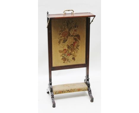 A 19TH CENTURY ROSEWOOD FIRESCREEN fitted decorative brass handle, with retractable needlework panel with a rise and fall she