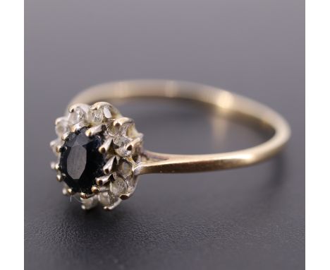 A sapphire, white paste and 9 ct gold flowerhead cluster ring, the oval sapphire of approx 0.3 ct, O/P, 1.2 g, (a/f)