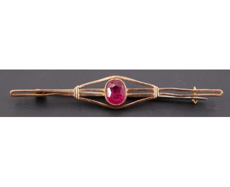 An early 20th Century ruby and 9 ct yellow metal bar brooch, the oval cut stone of approx 1 ct, 63 mm, 3 g