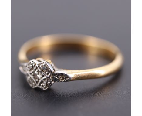 An Art Deco diamond ring, having a central old cut 2 mm diamond surrounded by four further diamonds, pave set as a cross in p