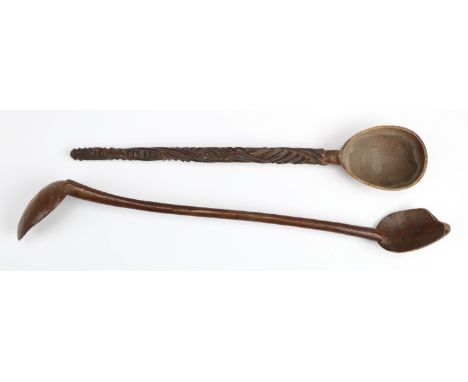 An antique ethnic carved wooden double-ended ladle together with a spoon, former 44 cm