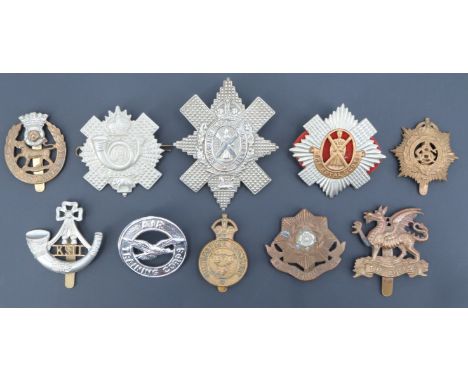 A small group of British army and other cap badges including a Shropshire Yeomanry badge