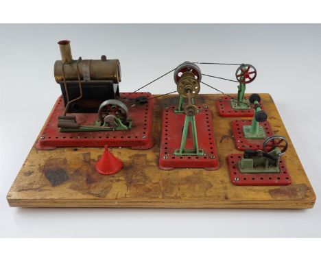 A group of Mamod workshop tools, machines and a steam engine, affixed to a wooden base, base 30.5 x 45.5 cm