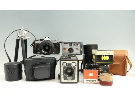 An Olympus OM-2 camera, Brownie model E, Instamatic 50 camera, Cosmic Symbol, two camera tripods, Olympus lens 1:1.8, F:50 mm