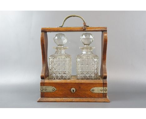 A late 19th / early 20th Century electroplate mounted tantalus, having a pair of hobnail cut spirit decanters with two keys, 