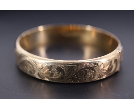 A silver gilt hinged bangle, of shallow D-section and foliate scroll engraved, Birmingham, 1976, 6 cm x 5.5 cm internally, 19