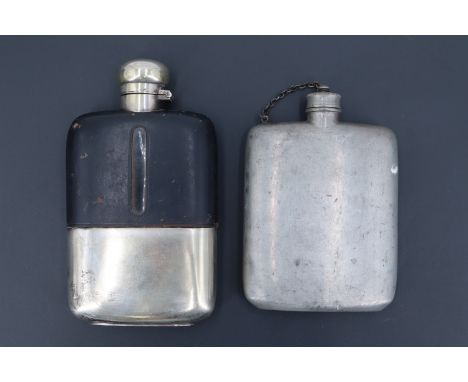 An early 20th Century electroplate-mounted hip flask, in glass, its leather covered shoulders having fill-level windows, havi