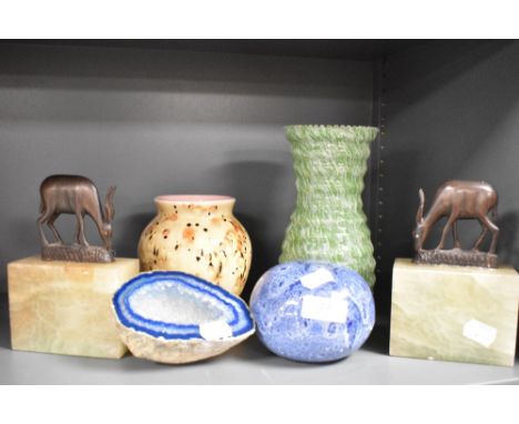 A pair of vintage Onyx book ends with wooden gazelle tops, a blue geode and studio pottery items.