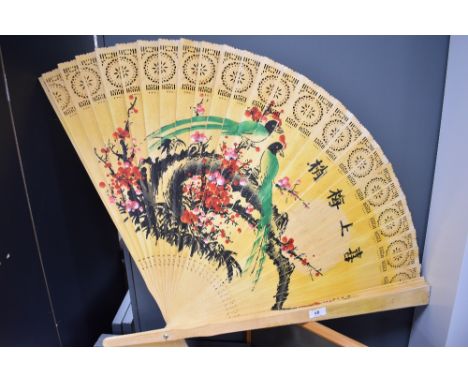 A large sized vintage Chinese fan with hand decorated wooden blades depicting birds of paradise.