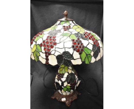 A vintage large Tiffany style laded light lamp having twin light to shade and light up central column decorated with grape vi