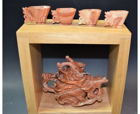 A carved Oriental Bander Ryolite teapot and four miniature toasting cups carved as stylised phoenix