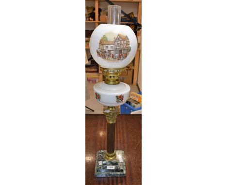 An oil lamp with matched glass font and shade printed with fox hunting scenes and tavern, mounted above Corinthian column on 