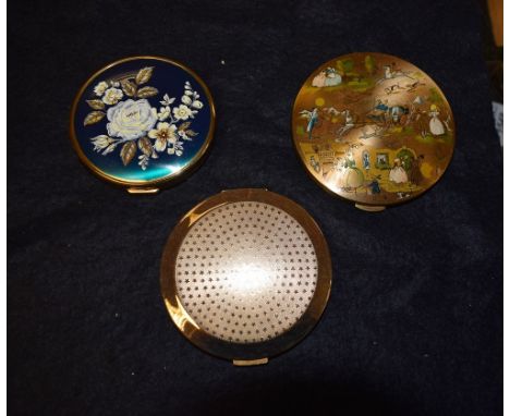 Powder compacts including a Kugi yellow metal compact, coaching scene decoration; a unused Stratton gold coloured engine turn