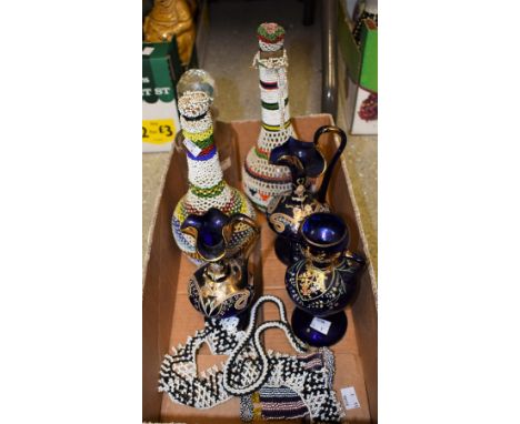 A pair of decorative blue glass ewers, enamelled with floral gilt scrolls, 21cm; a cylindrical clear glass decanter, engraved