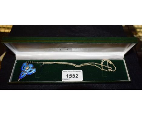 An Art Nouveau enamelled silver pendant, set with central pearl, shaded blue enamel; associated silver chain