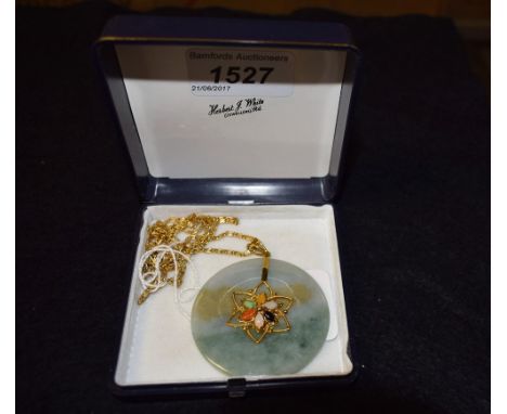 A jade 14ct gold mounted disc pendant, set with semi-precious stones to centre