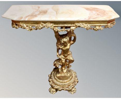 An ornate gilt and onyx topped console table on cherub pedestal support.