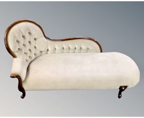 A Victorian style chaise longue upholstered in green button dralon.