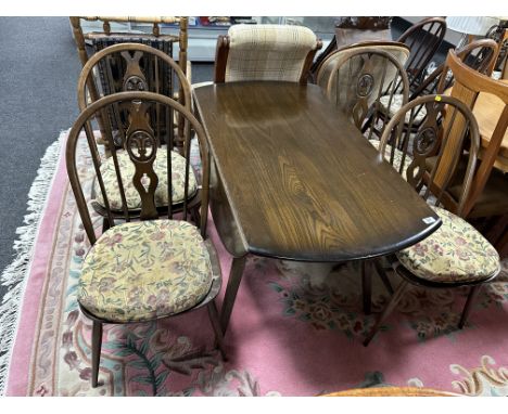 An Ercol stained elm and beech drop leaf table together with a set of four Fleur de Lys dining chairs