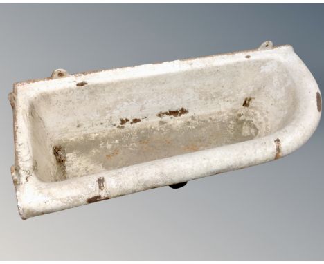 An antique cast iron wall mounted trough.