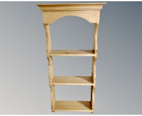 A narrow pine three tier wall shelf.