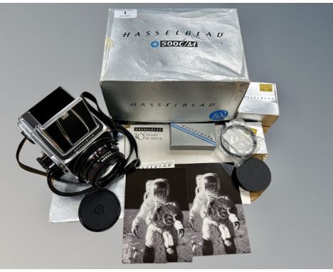 A Hasselblad 500C/M medium format SLR camera with Carl Zeiss planar 80mm F/2.8  lens, in original box with manual and accesso