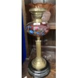 Victorian oil lamp black ceramic base, reeded brass column, cranberry glass reservoir with enamelled
