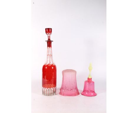 Victorian cranberry glass hand bell, a Bohemian style ruby and clear glass decanter and an etched cranberry glass lamp shade.