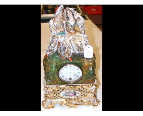 A decorative ceramic mantel clock - 44cm high CONDITION REPORTmans sword missing, head piece of lady missing a bit