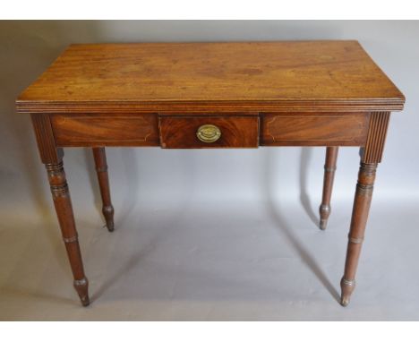A Regency Mahogany Tea Table, the reeded hinged top above a frieze drawer with oval brass handle, raised upon ring turned tap