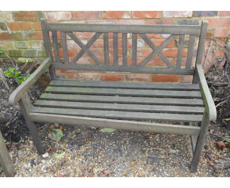 A Teak Garden Bench with Slat Work Seat, raised upon square legs together with a teak garden table