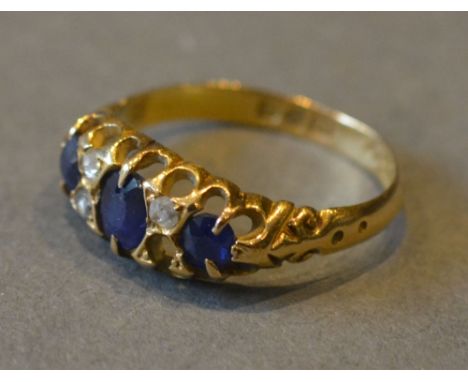 An 18ct. Yellow Gold Sapphire and Diamond Ring set with three sapphires interspaced with diamonds within a pierced setting