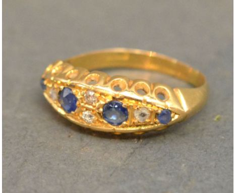 An 18ct Yellow Gold Sapphire and Diamond Ring, set with four sapphires surrounded by diamonds within a pierced setting