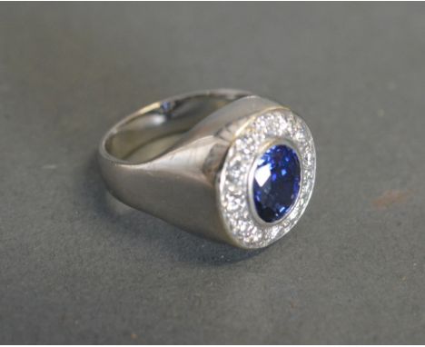 An 18ct White Gold Sapphire and Diamond Cluster Ring with a central oval sapphire surrounded by diamonds