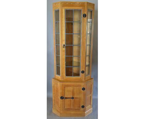 Robert (Mouseman) Thompson, A Light Oak Standing Corner Cabinet with a lead glazed door flanked by lead glazed panels, the lo