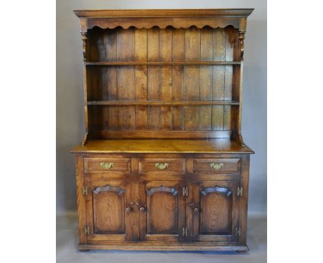 A 20th Century Oak Dresser, the boarded shelf back above three drawers and three moulded cupboard doors flanked by stiles, 13