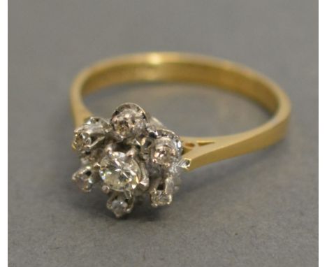 An 18ct. Yellow Gold Diamond Cluster Ring with a central diamond surrounded by diamonds within a pierced setting