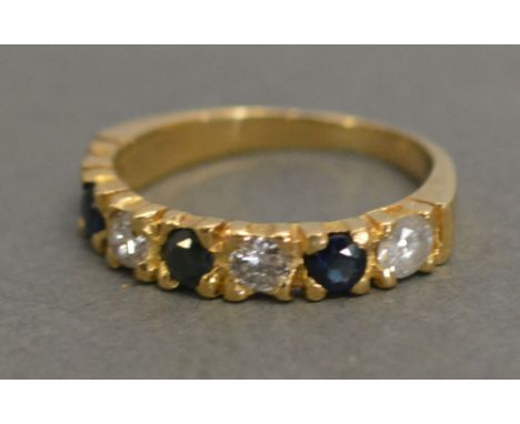 A 15ct. Gold Sapphire and Diamond Band Ring, set with three diamonds and three sapphires