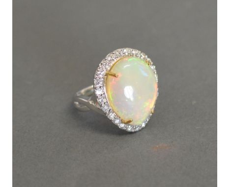 An 18ct White Gold Opal and Diamond Cluster Ring, the pear shaped opal approximately 10.60ct, approximately 1ct of diamonds