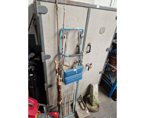 A bundle of vintage fishing rods/walking stick together with a rowing machine.  