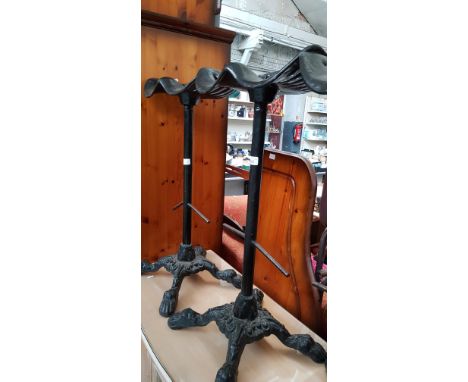 A pair of cast iron tractor seat bar stools, height 82cm (overall).  