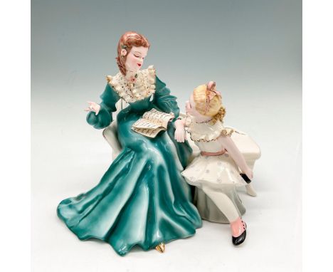 Glossy figure with young woman reading a story to younger girl. Dressed in period attire with gilt edges and floral accents o