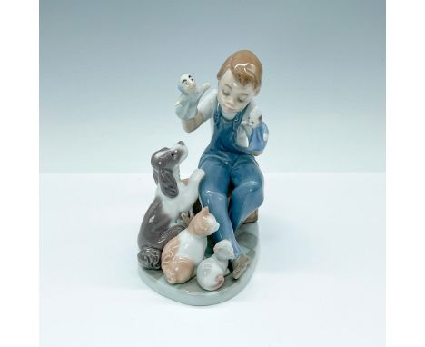 Adorable figurine portraying a young boy and his puppet show's pet audience. Lladro backstamp. Artist: Joan CoderchIssued: 19