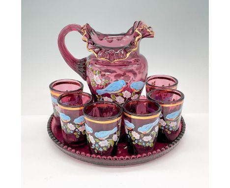 This charming grouping comprises a hand-painted ruffled neck pitcher, six tiny glasses, and a tray, all crafted in purple ame