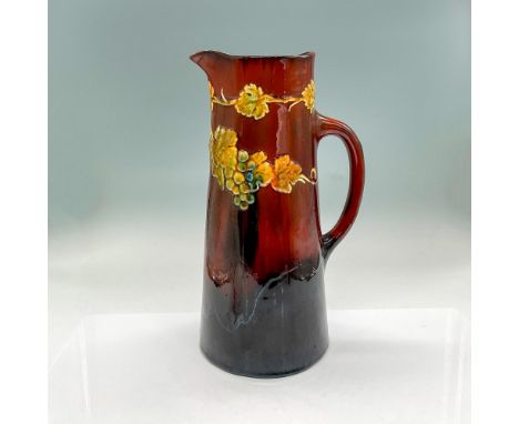 Tall earthenware pitcher in rich brown accented with green and blue berries, green leaves in high-relief. Dimensions: 6.75"L 