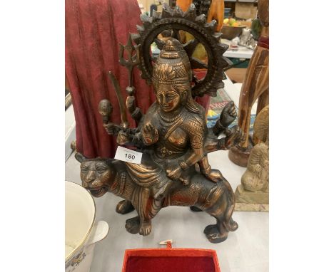 A BRONZE COLOURED, EXOTIC INDIAN MOTHER GODDESS ON A TIGER'S BACK, HEIGHT 38CM, LENGTH 28CM 