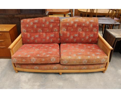 AN ERCOL ELM FRAMED BERGERE THREE SEATER SETTEE 